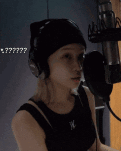 a woman wearing headphones and a black tank top with the letter w on the front