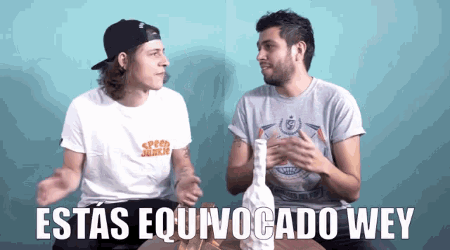 a man wearing a speed junkie t-shirt is talking to another man