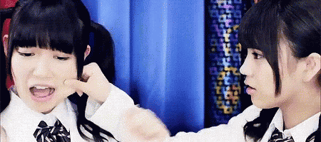 two girls are playing with each other and one of them is making a face