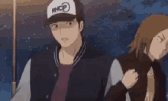 a man wearing a baseball cap is pointing at something in the distance .