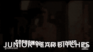a woman is holding a baby in her arms and the words junior year bitches are written on the screen .
