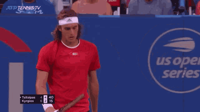 a man in a red shirt is standing in front of a us open series sign