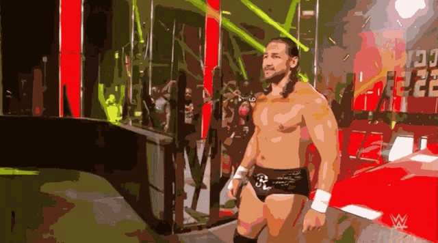 a shirtless wrestler is walking into a ring with the number 22 on the wall behind him