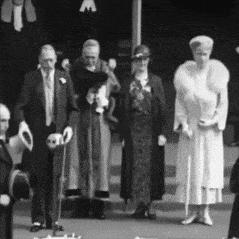a black and white photo of a group of people standing next to each other .