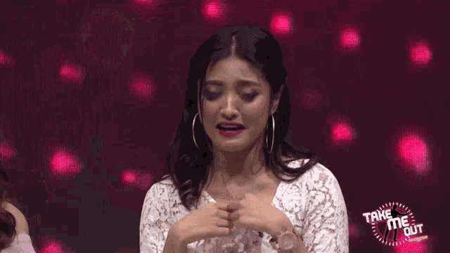 a woman making a heart shape with her hands in front of a take me out logo
