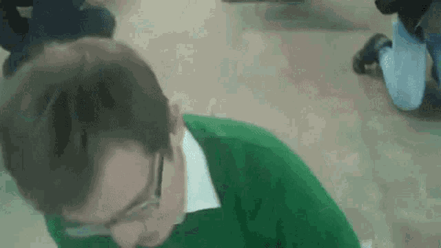 a man wearing glasses and a green sweater