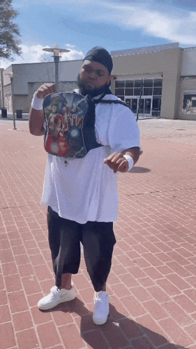 a man standing on a brick sidewalk wearing a shirt that says ' i am iron man '