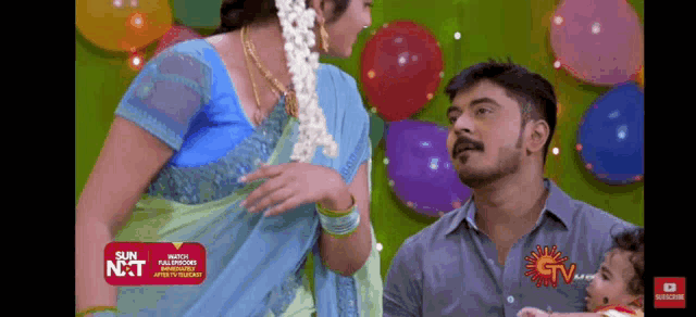 a man and a woman are standing next to each other with balloons in the background ..