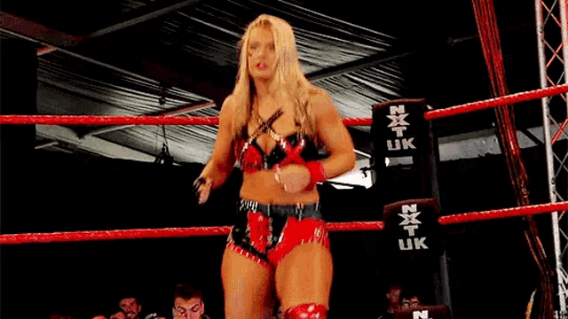 a woman is standing in a boxing ring holding a microphone .
