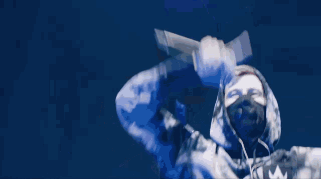 a man wearing a mask and a tie dye hoodie with the letter a on it