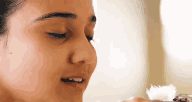 a close up of a woman 's face with her eyes closed and her mouth open