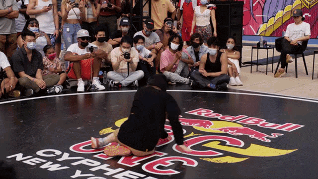a group of people are sitting on the ground at a red bull cypher in new york