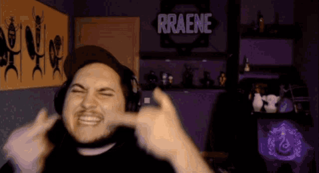 a man is making a face in front of a sign that says rraene