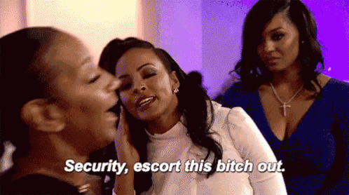 a group of women are standing next to each other and one of them is saying `` security , escort this bitch out . ''