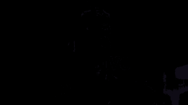 a man in a flash costume is standing in the street at night .