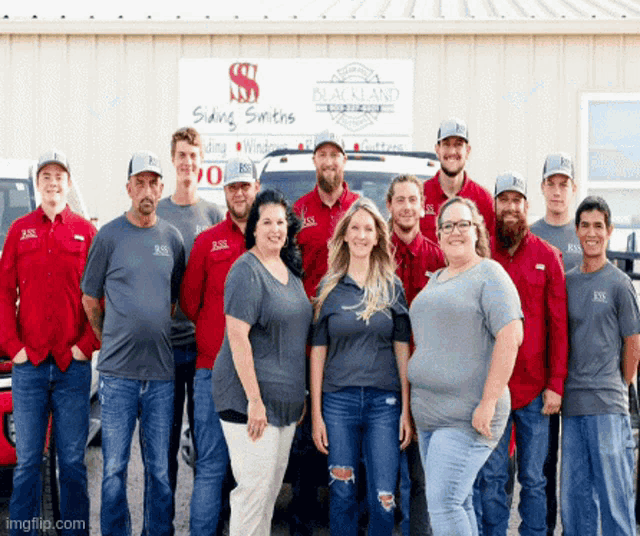 a group of people are posing for a picture in front of a sign that says blackland siding smiths