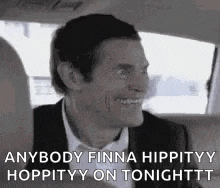 a man in a suit and tie is smiling in a car .