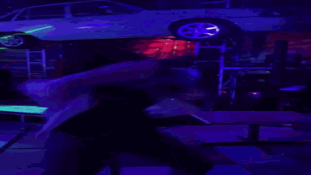 a blurry picture of a person standing in a dark room with purple lights