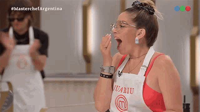 a woman wearing an apron with the letter m on it yawning
