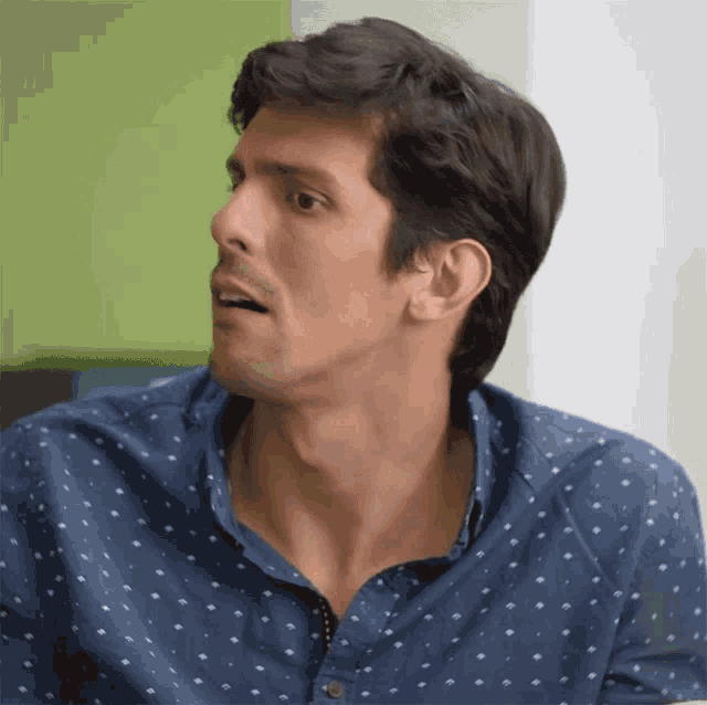a man wearing a blue shirt with white polka dots