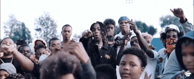 a group of people are standing in a crowd and one of them is giving the middle finger