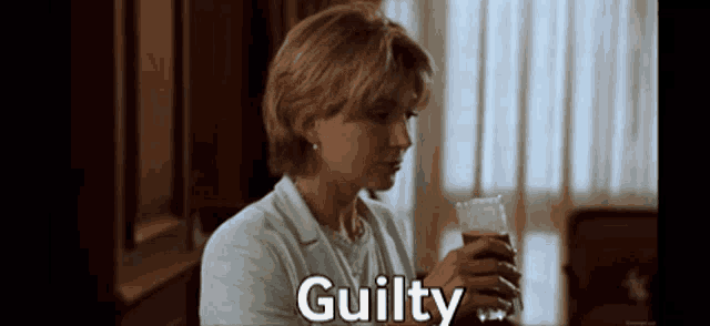 a woman is holding a glass of beer and the word guilty is above her