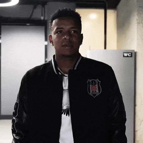 a man wearing a black jacket that says bjk 1903 on the front