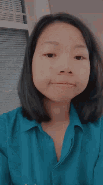 a girl in a blue shirt with the letter t on the front