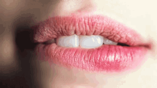 a close up of a woman 's lips with white teeth
