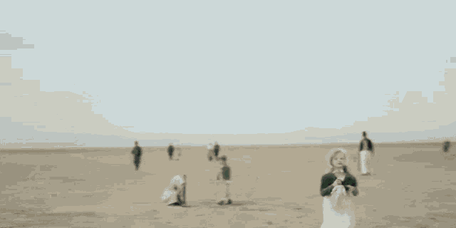 a little girl in a green dress is running in a desert .