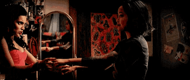 a man and a woman are dancing in front of a mirror .