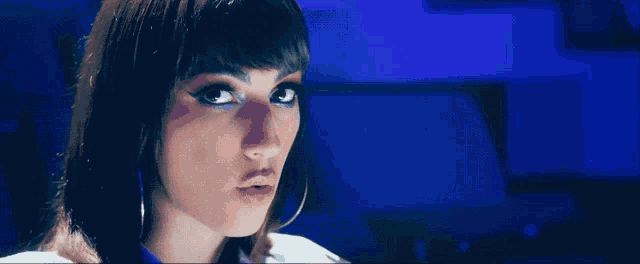 a close up of a woman 's face with a blue light behind her