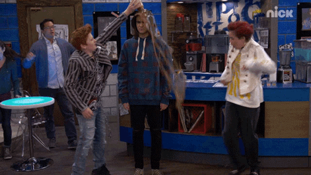 a group of people are standing in front of a nick sign
