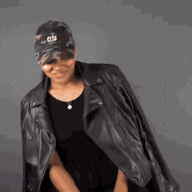 a woman wearing a leather jacket and a hat that says csv