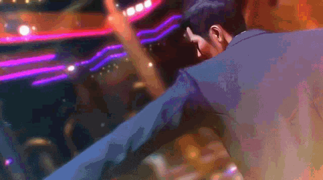 a man in a suit is dancing on a stage in a club