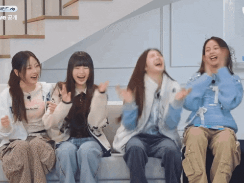 a group of girls are sitting on a couch and one of them has the number 1 on her sweater