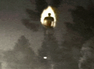 a silhouette of a man walking through a tunnel with a light coming out of it .