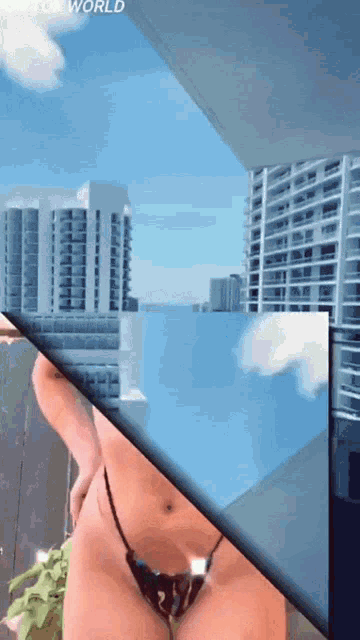a woman in a bikini stands on a balcony overlooking a city with the word world at the top