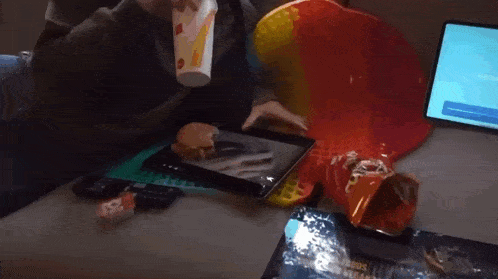 a person is playing a game on a tablet next to a bag of chips
