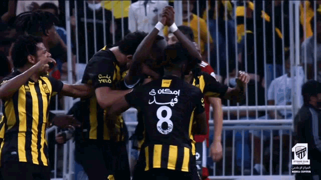 a group of soccer players with one wearing a jersey with the number 8 on it
