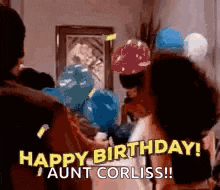 a group of people are standing in a room with balloons and a man is holding a balloon .