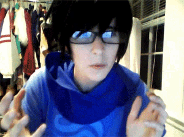 a person wearing glasses and a blue shirt is making a face