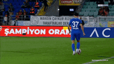 a soccer player with the number 37 on his jersey is kicking a ball