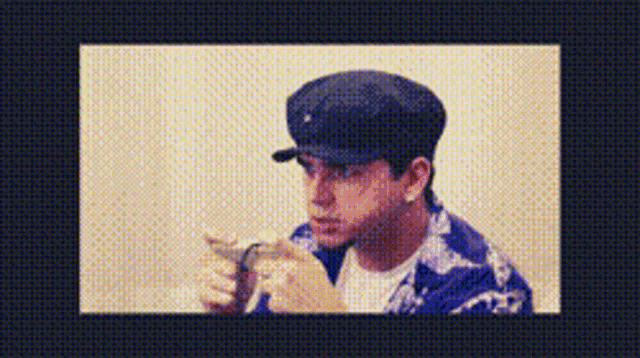 a man wearing a baseball cap is playing a video game on his phone