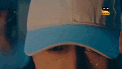 a close up of a person wearing a blue and white hat .