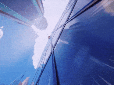 a person is climbing up the side of a blue building