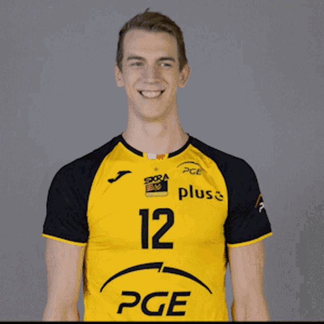 a man is wearing a yellow and black pge shirt