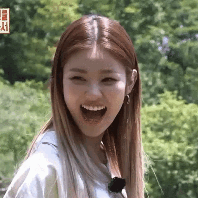 a woman with long hair is laughing with her mouth wide open .