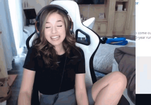a woman wearing headphones sits in a gaming chair with her eyes closed