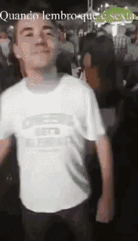 a man in a white shirt is dancing in a crowd of people .